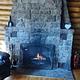 Stone fireplace, chair, logs, fireplace tools (poker, shovel, broom) and fire extinguisher. 