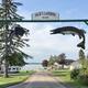 Entrance sign arch with 'Jack's Landing' and view straight down to the lodge and lake — clearly identifies the property entrance and grounds (from site background/entrance image).