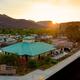 Vertical crop of the RV resort clubhouse and adjacent RV sites at sunset, showing site details, walkways and landscaping — complements the panoramic views with a closer perspective.