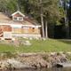 Exterior view of a lakeside cottage and dock on the property — shows building, shoreline and waterfront setting (used on the resort homepage/gallery).