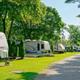 Row of RVs and pull-through sites along a gravel road; good close view of typical RV pitches and site spacing (matches the site’s ‘rvsites_hero’ image).