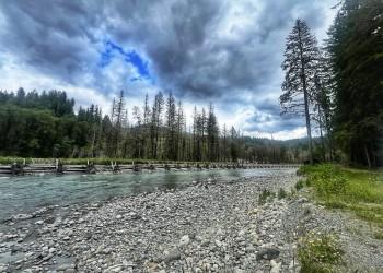 river with rock shore under cloudy sky