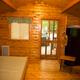 Interior photo of a cabin showing wood-paneled room, bed and kitchenette area — useful to illustrate cabin interior accommodations (source: Photos page).