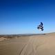 Motorcyclist jumps a dune