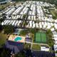 Clear aerial overview of the entire RV resort showing park layout, rows of RV lots, clubhouse, pool and multiple courts — matches facility descriptions on the site (facilities/pickleball/pool).