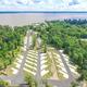 High-altitude aerial overview showing the campground layout, concrete RV pads arranged in rows, roads and shoreline with Lake Livingston in background — matches gallery/social image on the property site.