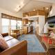 Interior living area of a cabin (kitchen, seating and loft stairs) — demonstrates the interior accommodations available at the resort (from the property gallery).