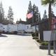 Ground-level view of the park drive, mailboxes and flag with RVs in background — helpful for entrance/onsite atmosphere and orientation (homepage/gallery context).