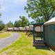 Row of canvas-covered yurts or wagon-style glamping units with campground road — highlights alternative lodging on the property.