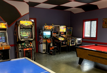 Arcade/recreation room with video games, pinball and pool table — interior facility photo useful for the campground’s amenities gallery.