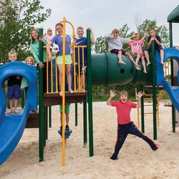 Playground area with play structures and children — useful to show on-site family facilities and play spaces for families considering the campground.