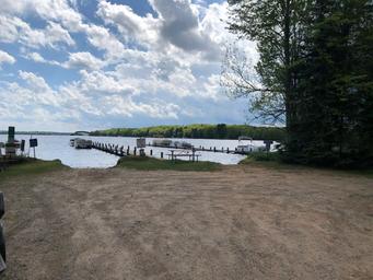 Lakeshore and dock scene on Pelican Lake with boat slips and shoreline — useful to show water access and marina facilities on the property.