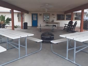 Covered pavilion photo with picnic tables and rocking chairs — highlights a communal amenity available to guests (Amenities page).