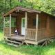 Front view of a rustic cabin on grass with porch — good representation of overnight cabin lodging on the property (site gallery context).