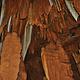 Copper-colored stalactites hang from the ceiling of Big Spring Cave