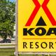 Virtual tour thumbnail from the Port Huron KOA page showing an on‑site scene with RVs, guests, and cornhole games — depicts the campground layout and recreational area.