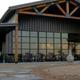 Frontal ground-level shot of the clubhouse/building with covered porch and seating; labeled in site’s amenities content as clubhouse groundshot (page: /amenities).