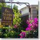 Clear, well-lit photograph of the Stone Villa entrance sign with landscaping and fence — establishes property identity and entrance ambience (used on RV Requirements / homepage).