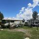 RV hook-ups and parking area: wide daylight shot showing multiple RVs on grassy pads with picnic tables and hookups (clearly depicts campground RV facilities; from 'General 2' page).