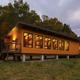 Clear exterior shot of a single cabin on stilts with deck and woodland behind — useful for showing accommodation style and building materials (from the property's gallery/overview page).