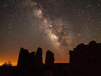 Ancient structures silhouetted against the night sky and the Milky Way