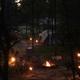 Nighttime scene of a campsite with a campfire and tent illuminated — conveys campground atmosphere and camping experience on the property. Included in homepage slideshow.