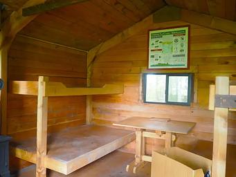 Gut Island Cabin 2 interior with wood table and wooden bunkbeds