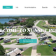 Aerial hero image from the site top page showing the waterfront RV resort layout, multiple RV pads, roads, lake shoreline and landscaping — strong overall property overview.