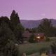 Twilight/hero-style view showing a cabin set in landscaped grounds — used as the site’s main social/hero image, useful as an attractive overall property shot.