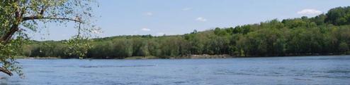 Wide river view showing the Potomac and wooded shoreline at the property (sunset/low-light) — from the homepage images, provides scenic overview of the campground’s river setting.
