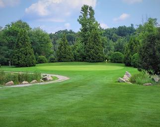 Well-framed view of a manicured green and fairway with landscape features — highlights the on-site golf facilities and course quality (from site’s gallery golf images).