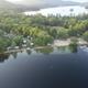 Aerial shoreline view with sandy beach, docks and parked boats — clearly depicts lakeside beach and marina amenities on the property (used on site background).