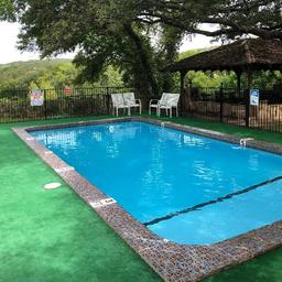 Swimming pool with fencing and pergola visible — clearly shows an on-site amenity (pool) and surrounding landscape; sourced from the resort 'Amenities' page.