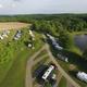 High-angle/drone view of RV sites, roadways and the pond giving a clear look at pitch layouts and terrain — labelled on the Overview page.