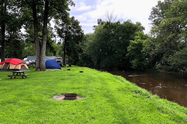 Tent campsites along a creek with grassy sites and picnic table — useful view of primitive/tent camping and creek frontage shown on the campground’s ‘Camping In Lancaster County’ content.